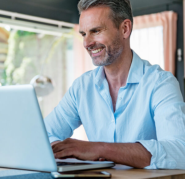 homme souriant sur son ordinateur