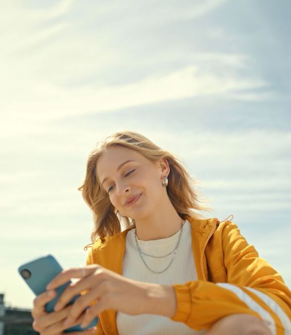 femme en jaune avec son telephone